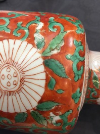 A Chinese famille verte coral-ground rouleau vase with peony scrolls, Kangxi