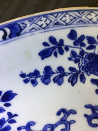 Een grote Chinese blauw-witte florale schotel en twee borden, Kangxi