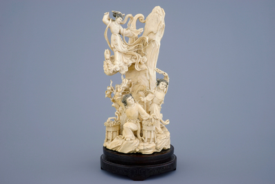 A Chinese carved ivory group of the moon goddess and two girls on a wooden base, 19/20th C.