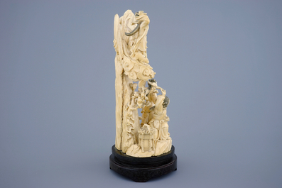 A Chinese carved ivory group of the moon goddess and two girls on a wooden base, 19/20th C.