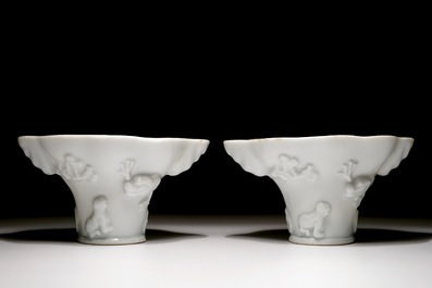 A pair of blanc de Chine relief decorated libation cups, Kangxi