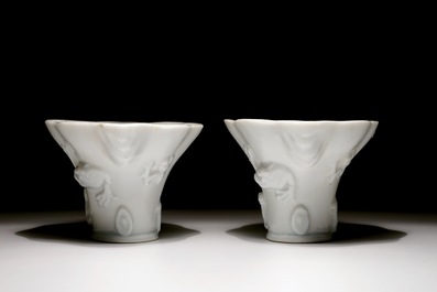 A pair of blanc de Chine relief decorated libation cups, Kangxi