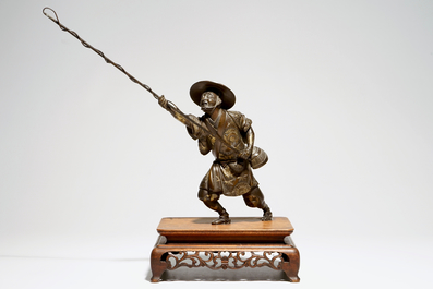 A Japanese bronze model of a fisherman on wooden base, Meiji, signed