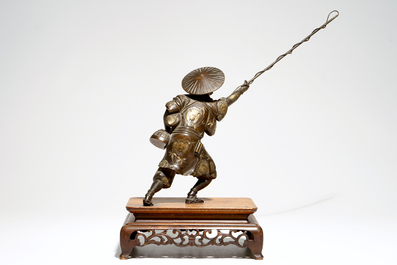 A Japanese bronze model of a fisherman on wooden base, Meiji, signed