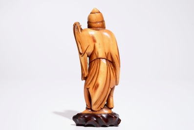 Een Chinese ivoren figuur van een man met een theepot, 18e eeuw