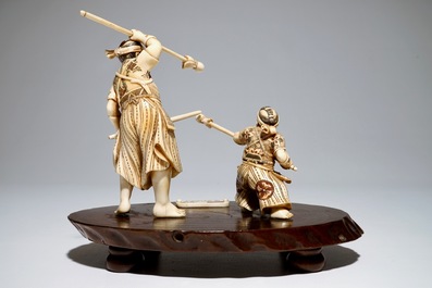 A Japanese ivory group of a warrior and his pupil, on a wooden base, Meiji, signed