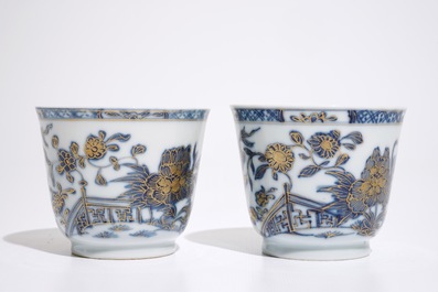 A pair of Chinese blue, white and gilt cups and saucers, Qianlong