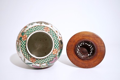 A Chinese famille rose warriors jar with wooden cover, 19th C.