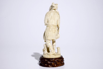 A Japanese ivory okimono of a fisherman on wooden base, Meiji, 19th C., signed