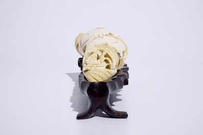 A Chinese shell-shaped ivory group on wooden stand, early 20th C.