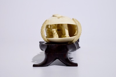 A Chinese shell-shaped ivory group on wooden stand, early 20th C.