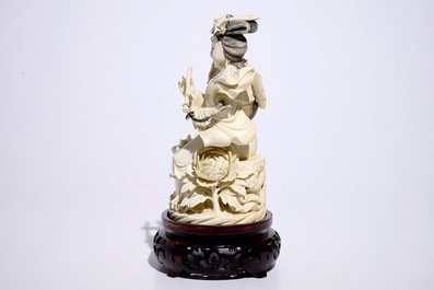 A Chinese ivory figure of a lady playing a flute on wooden base, early 20th C.