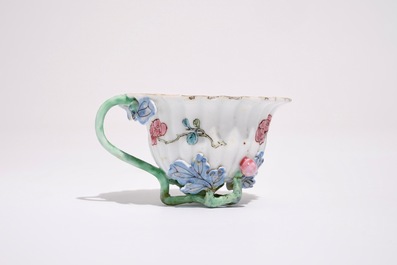 A Chinese famille rose lotus-shaped relief-decorated cup and saucer, Yongzheng