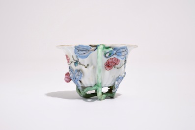 A Chinese famille rose lotus-shaped relief-decorated cup and saucer, Yongzheng