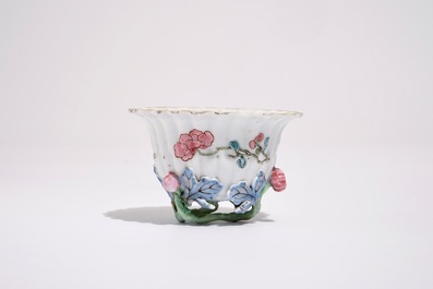 A Chinese famille rose lotus-shaped relief-decorated cup and saucer, Yongzheng