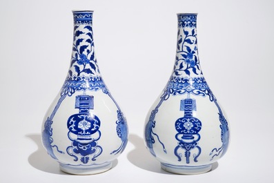 Une paire de vases de forme bouteille en porcelaine de Chine bleu et blanc, Kangxi