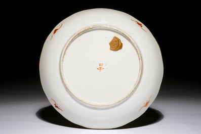Une assiette en porcelaine de Chine &agrave; d&eacute;cor de calligraphie et marques en rouge de fer et noir, 19/20&egrave;me