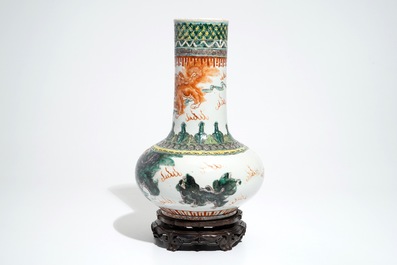 A Chinese famille verte vase with Buddhist lions on wooden stand, 19th C.