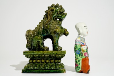 Een Chinese famille rose figuur van een knielende jongen en een Ming-stijl tempelleeuw, 19e eeuw