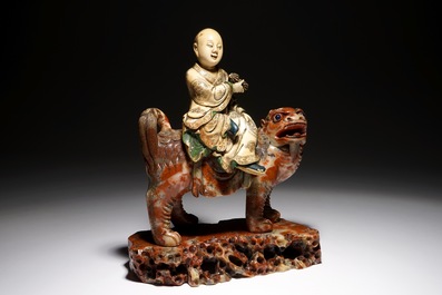 A Chinese soapstone figure of the immortal Vajraputra on a Buddhist lion, Kangxi/Qianlong