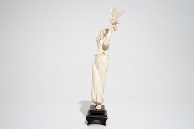 A Chinese ivory figure of a lady with a butterfly, early 20th C.