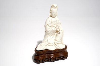 A Chinese Dehua blanc de Chine Guanyin on wooden stand, Kangxi