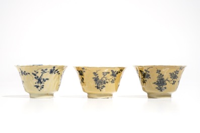 Three Chinese blue and white and caf&eacute; au lait-glazed cups and saucers, Kangxi