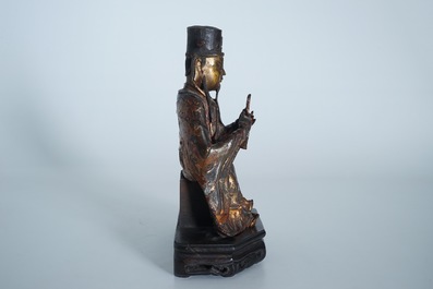 A Chinese partly gilt and polychrome bronze figure of Wenchang Dijun on wooden stand, Ming