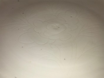 Un plat en porcelaine blanc de Chine &agrave; d&eacute;cor floral incis&eacute;, Kangxi