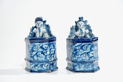 Une paire de figures d'enfants assis en fa&iuml;ence de Delft bleu et blanc, 18&egrave;me