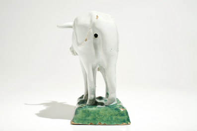 A white Dutch Delft model of a cow on a green base, 18th C.