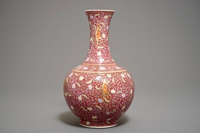 A Chinese ruby-ground famille rose bottle vase with dancing boys, Qianlong mark, 19/20th C.