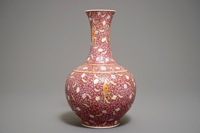 A Chinese ruby-ground famille rose bottle vase with dancing boys, Qianlong mark, 19/20th C.