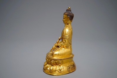 A Tibetan gilt bronze figure of Buddha with vajra, 19th C.