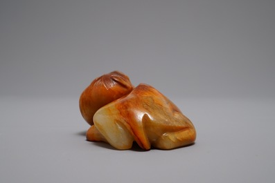 A Chinese carved russet jade model of a reclining horse, 19/20th C.