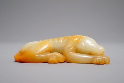 Een Chinees model van een liggende hond in gevlekte jade, 19/20e eeuw