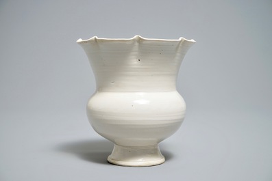 A Chinese foliate-rimmed cream-glazed dingyao bowl on foot, Song or later