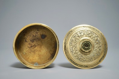 A round Chinese gilt copper-alloy box and cover with floral design, 18/19th C.