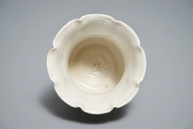 A Chinese foliate-rimmed cream-glazed dingyao bowl on foot, Song or later