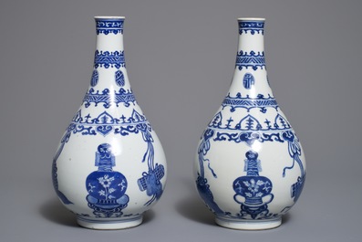 A pair of Chinese blue and white bottle vases with ribbons and precious objects, Kangxi