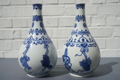 Een paar Chinese blauwwitte flesvormige vazen met kostbaarheden en franjes, Kangxi