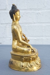 A Tibetan gilt bronze figure of Buddha with vajra, 19th C.