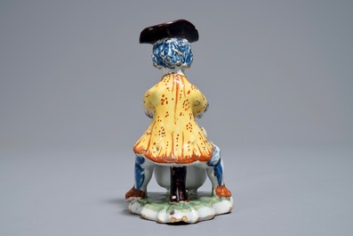 A polychrome Dutch Delft model of a man near a stove, 18th C.