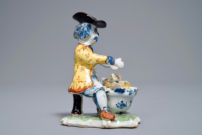 A polychrome Dutch Delft model of a man near a stove, 18th C.