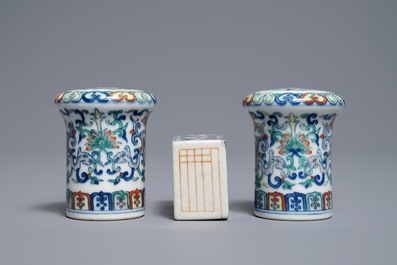 A pair of Chinese doucai scroll ends and a famille rose paper weight, 19/20th C.