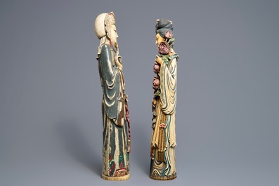 A pair of tall Chinese polychrome ivory figures on wooden bases, 19th C.