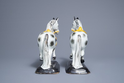 A pair of polychrome Dutch Delft black and yellow models of circus horses, 19th C.