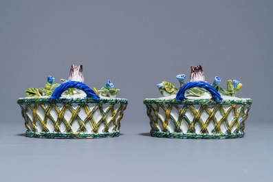 Une paire de beurriers &agrave; d&eacute;cor en relief sur supports ajour&eacute;s en fa&iuml;ence polychrome de Delft, 18&egrave;me