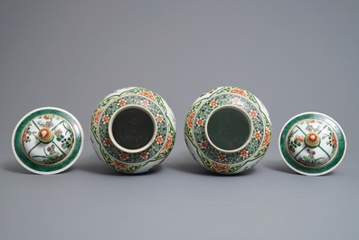 A pair of Chinese famille verte vases and covers with birds and flowers, 19th C.