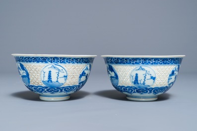 A pair of Chinese blue and white reticulated bowls with landscape panels, Transitional period